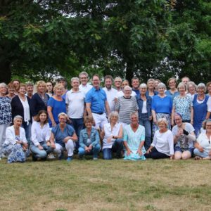 Een groep mensen poseren voor een foto in een park.
