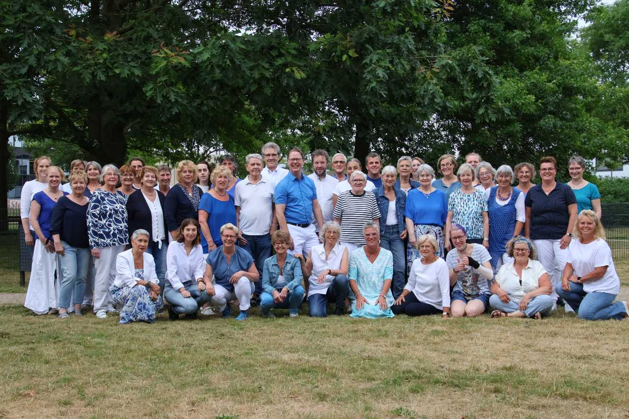 Een groep mensen poseren voor een foto in een park.