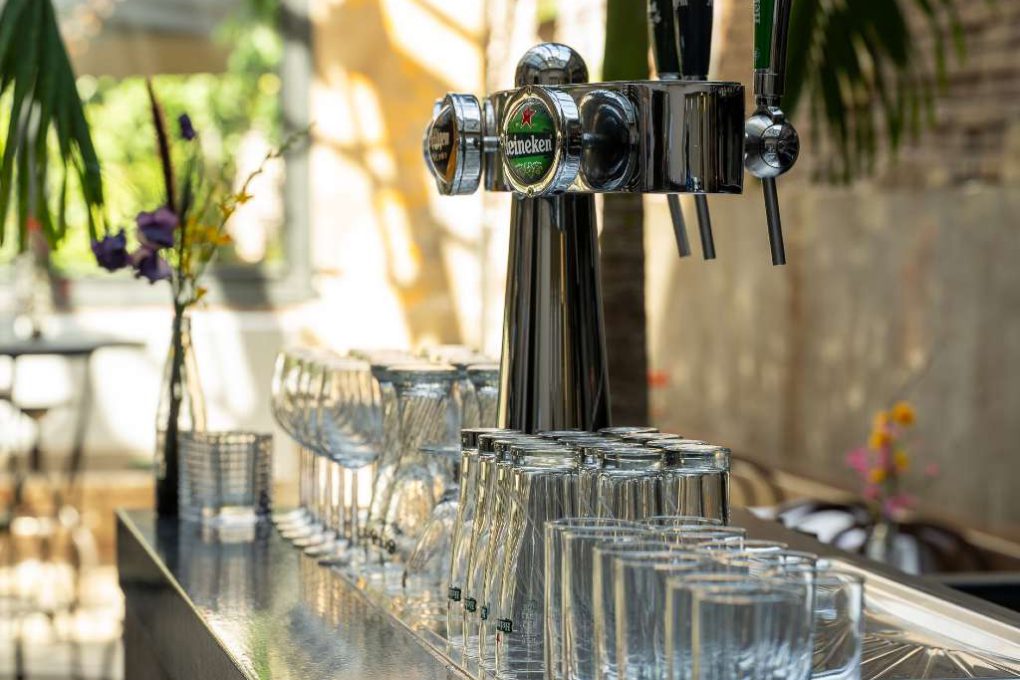 Een bar met glazen en een biertap.