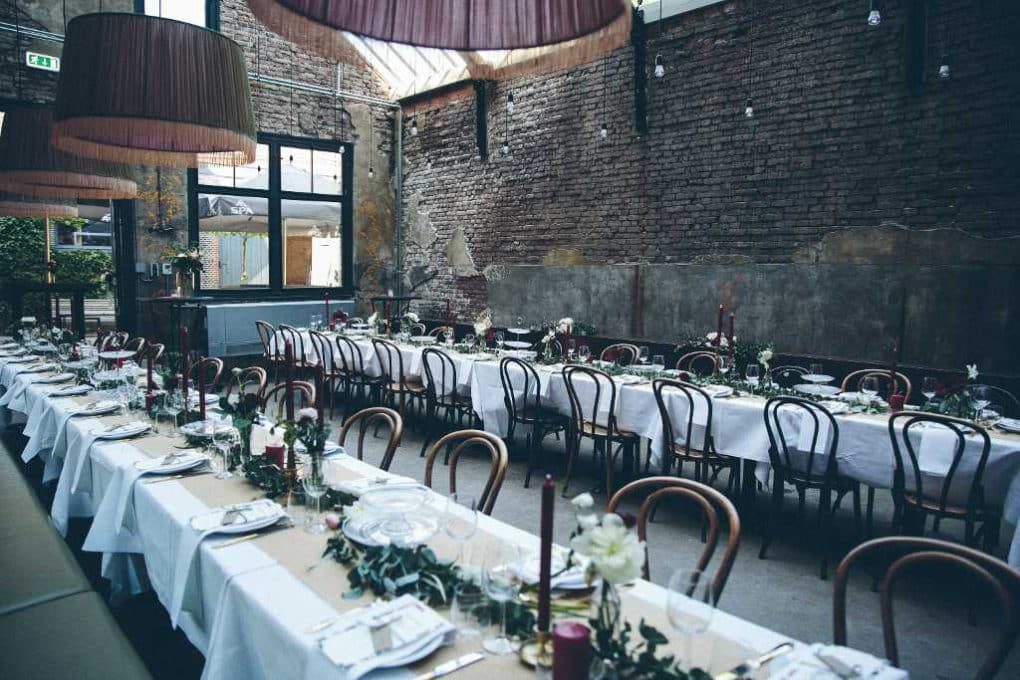 A long table is set up in a brick building.