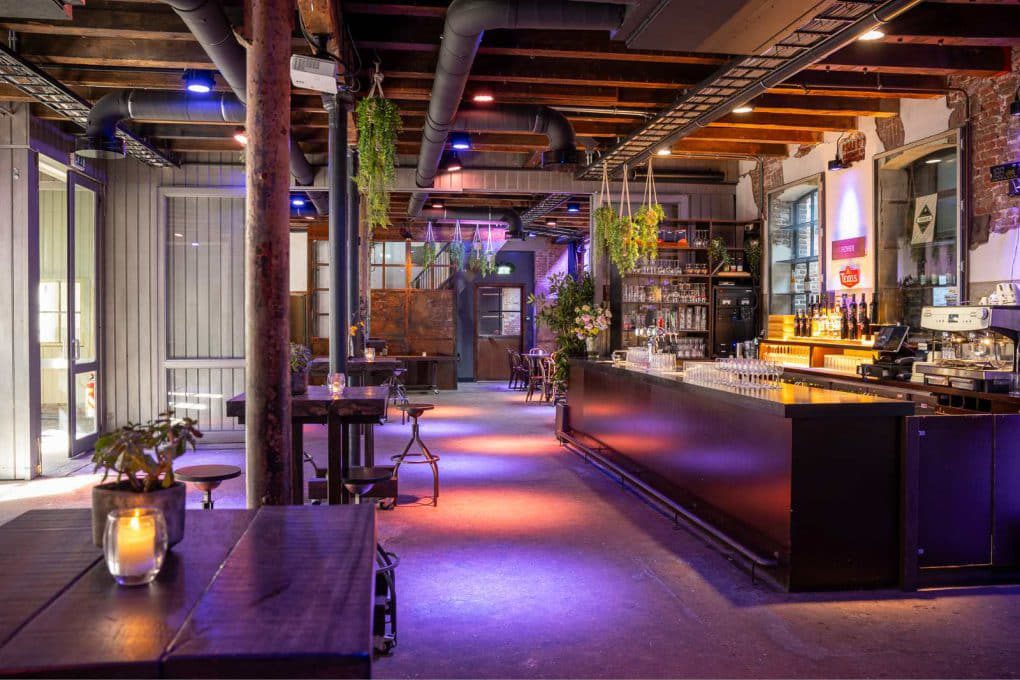 The interior of a bar with purple lighting.