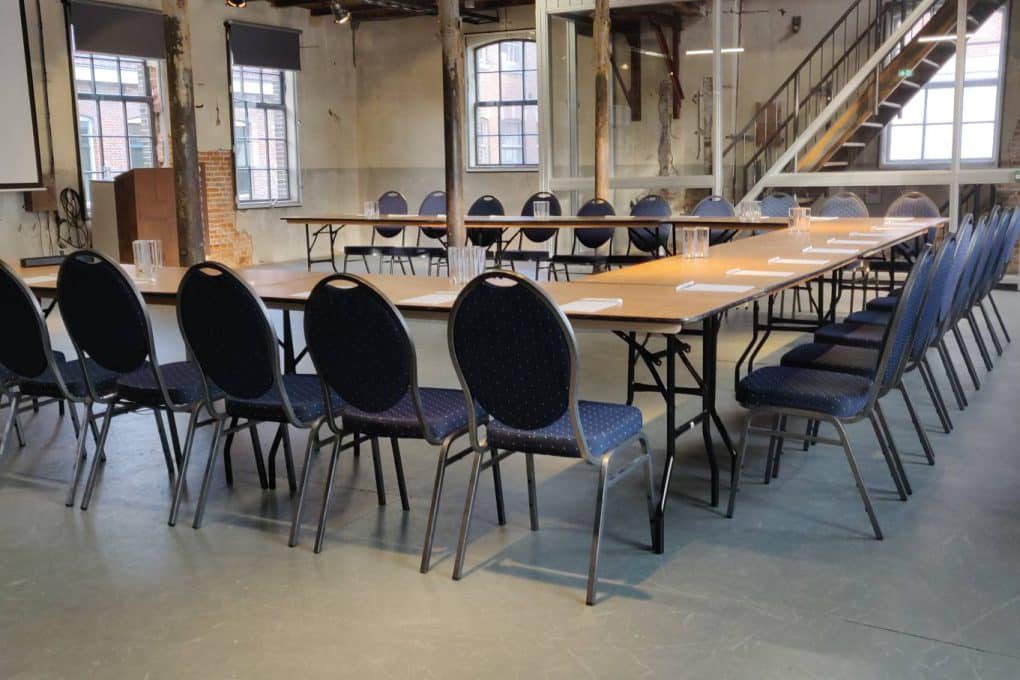 A large conference room with a long table and chairs.
