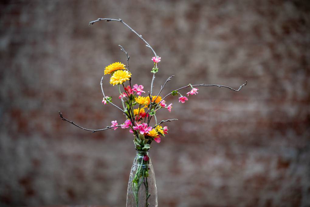 Een vaas met bloemen erin op een tafel.